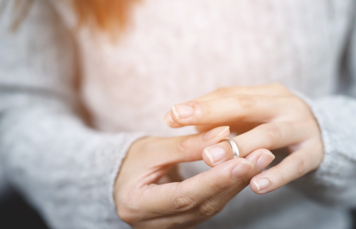femeie care-și dă jos verigheta după divorț