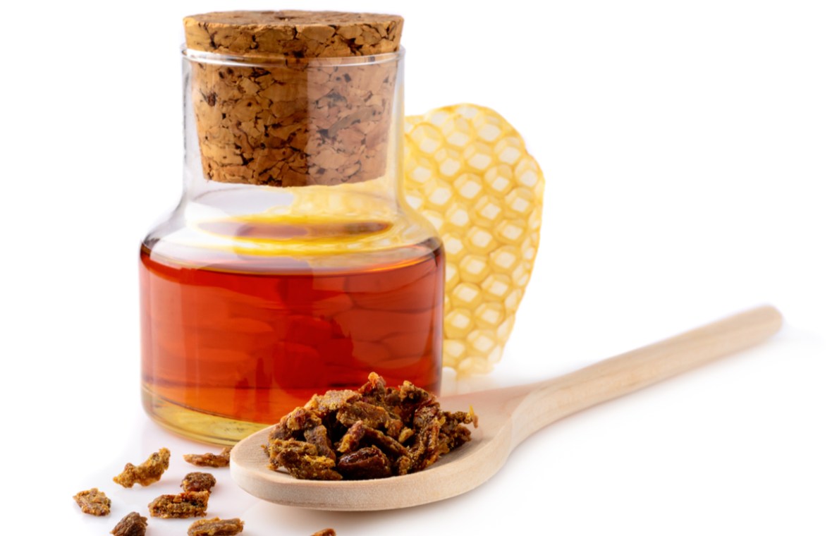tinctura de propolis beneficii administrare si contraindicatii. sticluta cu tinctura de propolis, granule de propolis si o bucata de fagure cu miere
