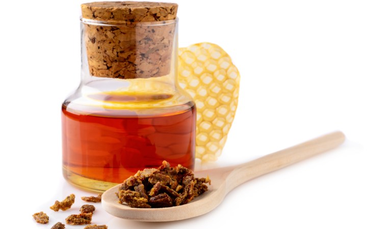 tinctura de propolis beneficii administrare si contraindicatii. sticluta cu tinctura de propolis, granule de propolis si o bucata de fagure cu miere