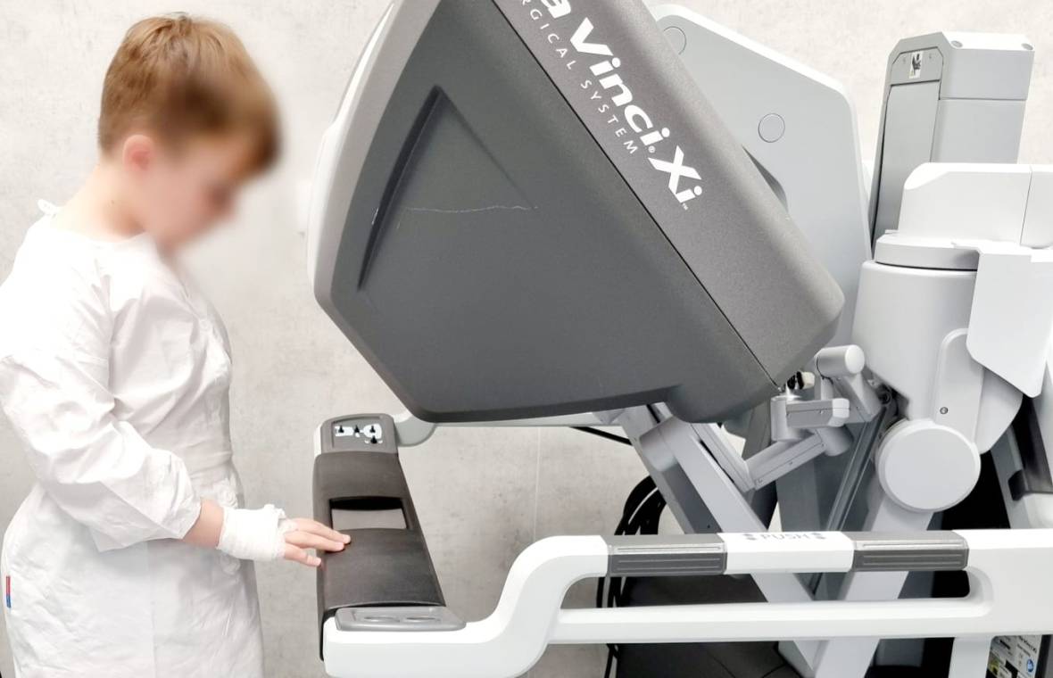 Alexandru, un băiețel în vârstă de 8 ani, se joacă cu robotul da Vinci Xi