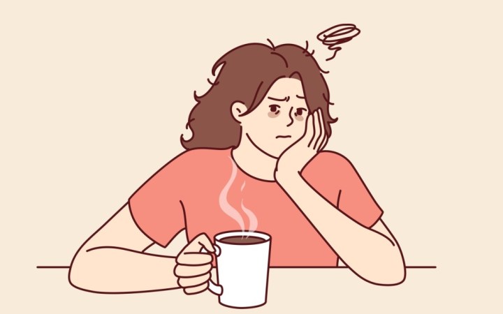 intoleranta la cafea. femeie cu durere de cap in timp ce bea cafea