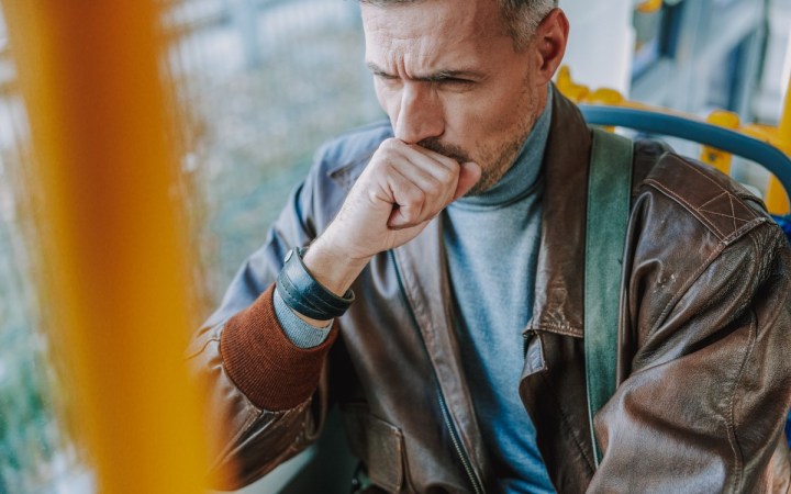 tusea după răceală. bărbat care tușește în mijloc de transport în comun