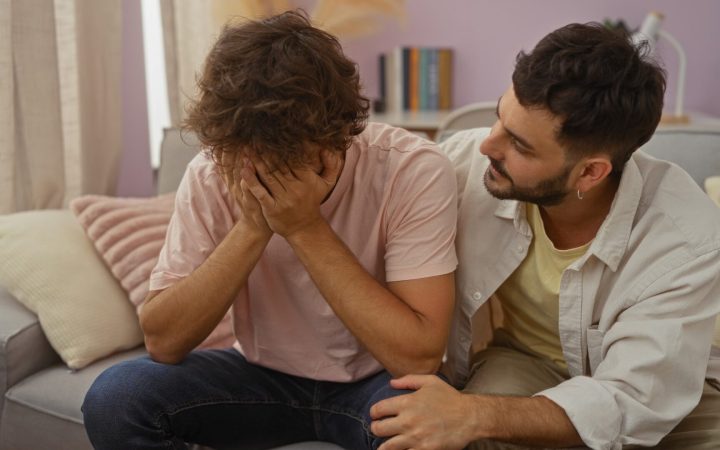 Un bărbat îl încurajează pe alt bărbat trist să meargă la psiholog