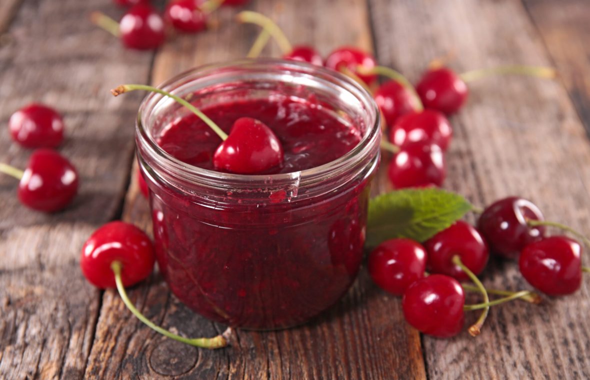dulceață de cireșe într-un borcan, cu cireșe lângă