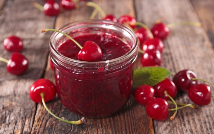 dulceață de cireșe într-un borcan, cu cireșe lângă