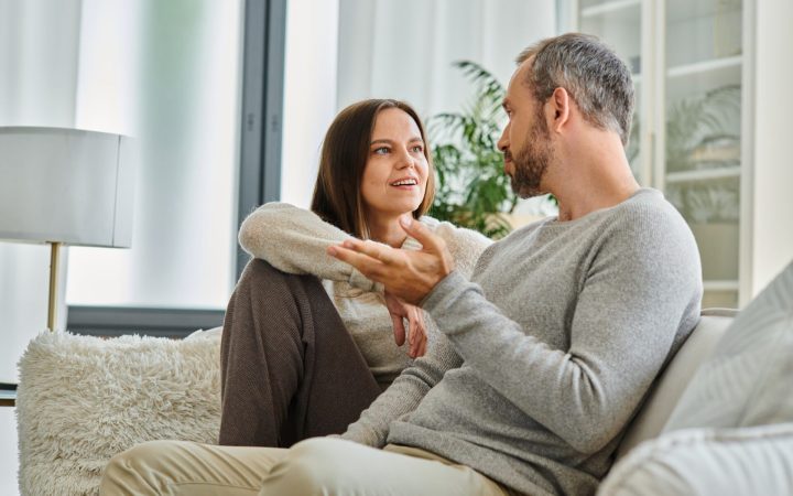 Cuplu care comunică liniștit pe canapea