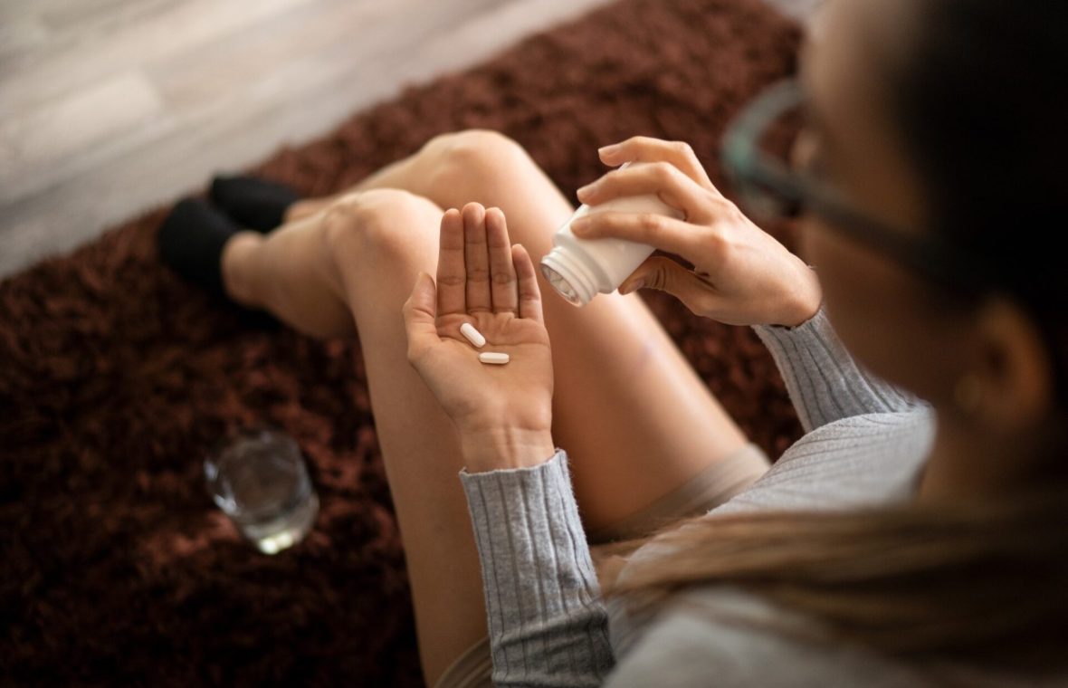femeie care ia pastile de paracetamol