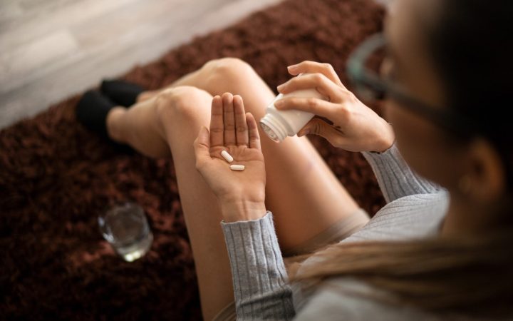 femeie care ia pastile de paracetamol