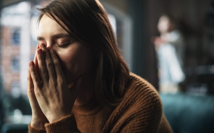 abuz emoțional în cuplu. femeia este victimă, bărbatul țipă în fundal