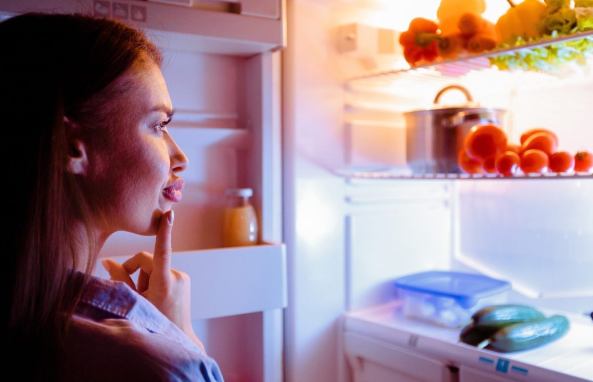 femeie alege alimente din frigider pentru cină