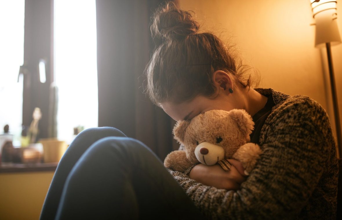 mama care plânge cu jucăria ursuleț de pluș a copilului strânsă în brațe