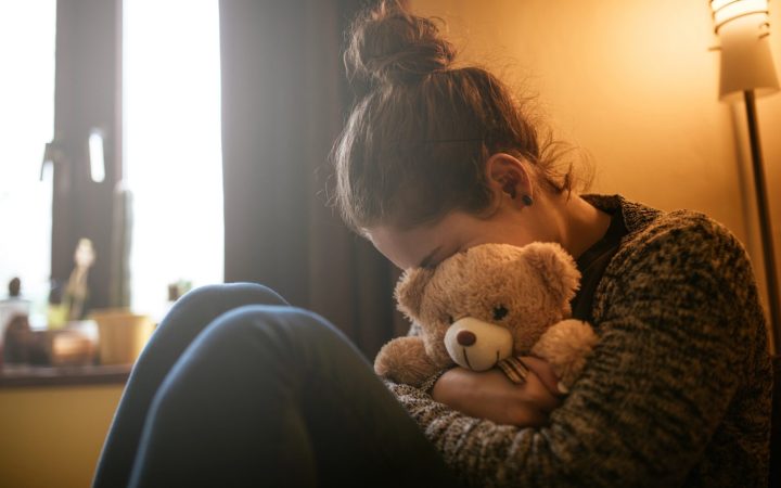 mama care plânge cu jucăria ursuleț de pluș a copilului strânsă în brațe