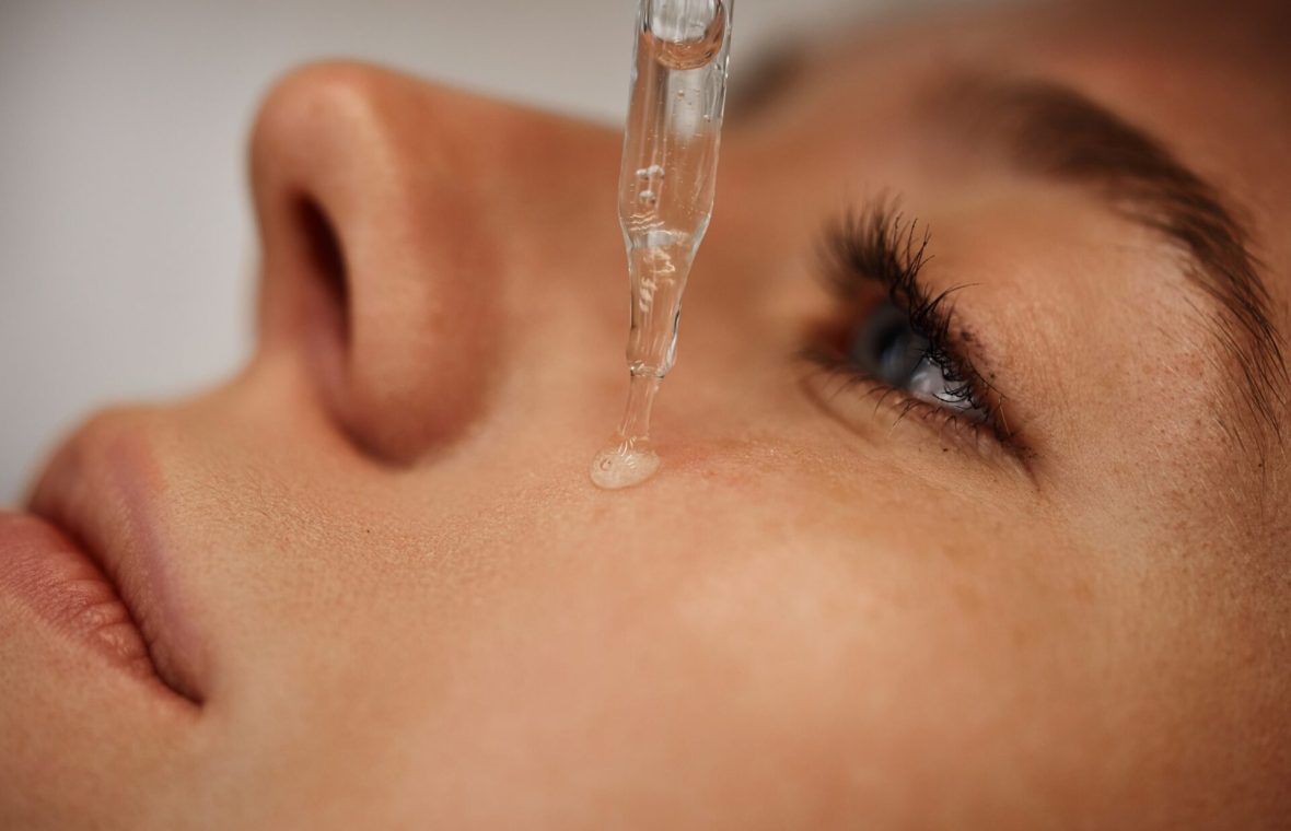 femeie își aplică ser cu niacinamide pe față