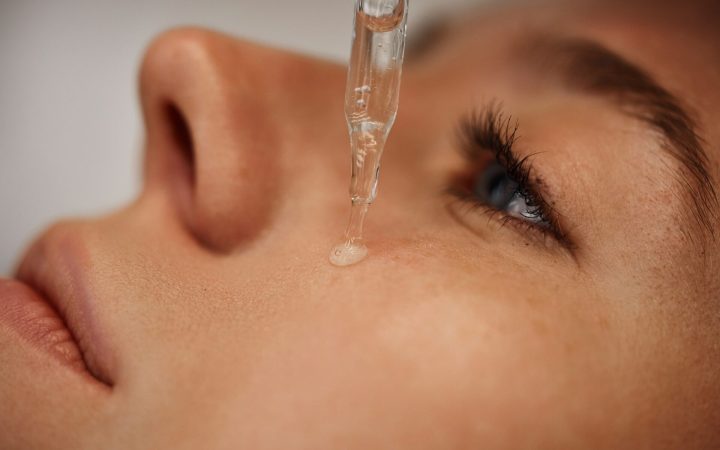 femeie își aplică ser cu niacinamide pe față