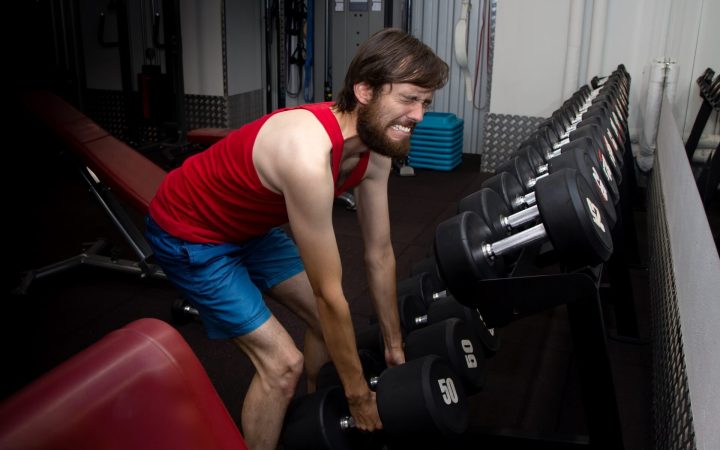 bărbat care se chinuiește să ridice greutăți cu masă musculară scăzută și probleme hormonale