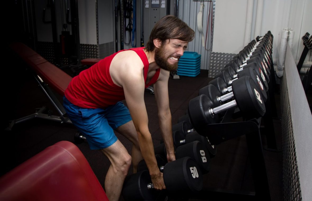 bărbat care se chinuiește să ridice greutăți cu masă musculară scăzută și probleme hormonale