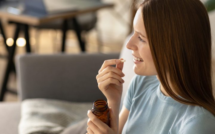 femeie care ia supliment cu siliciu pentru păr și piele