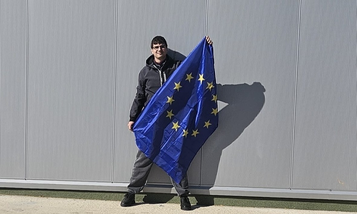 Tânăr diagnosticat cu schizofrenie ține în mână steagul Uniunii Europene
