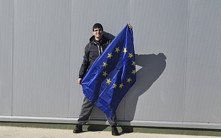 Tânăr diagnosticat cu schizofrenie ține în mână steagul Uniunii Europene