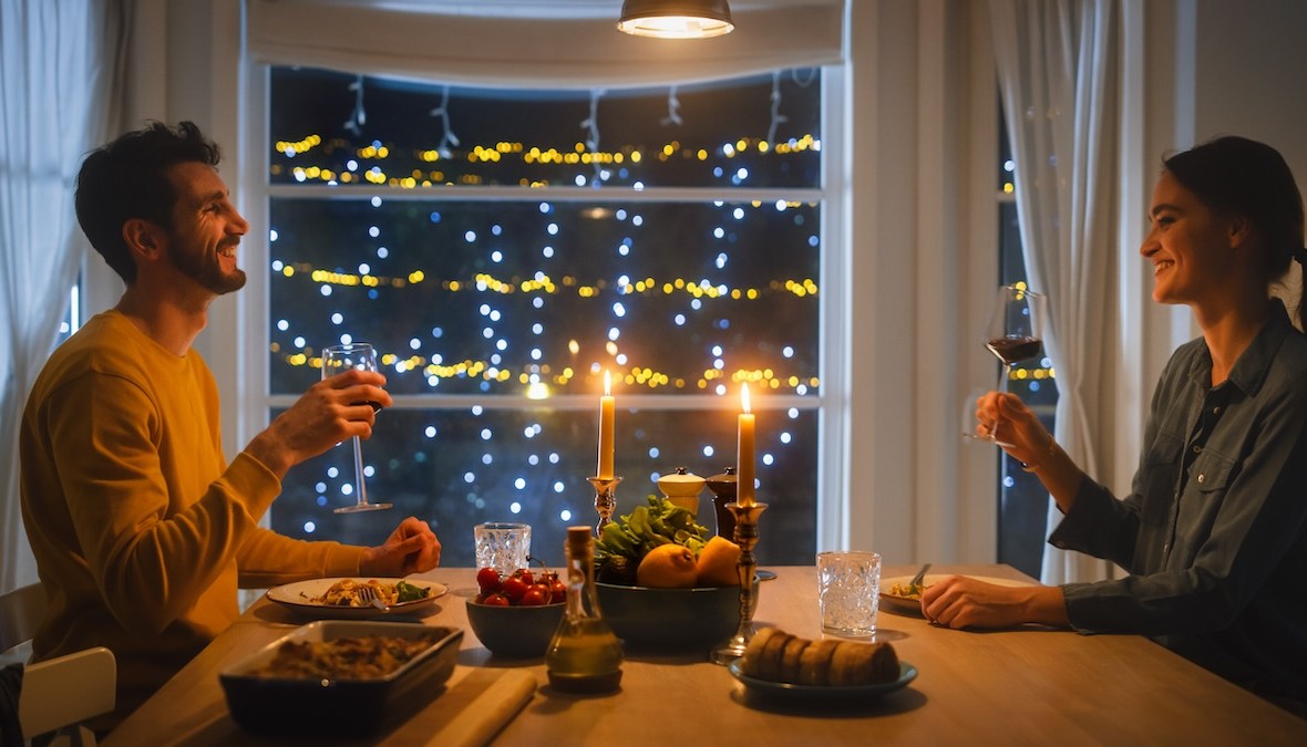 cuplu tânăr romantic iau cina decor cu luminițe