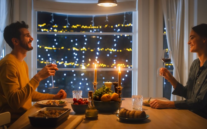 cuplu tânăr romantic iau cina decor cu luminițe