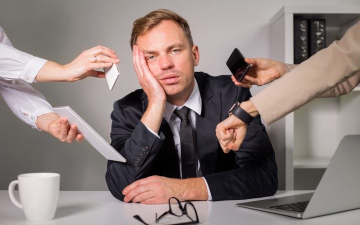 bărbat copleșit de prea multe sarcini la job