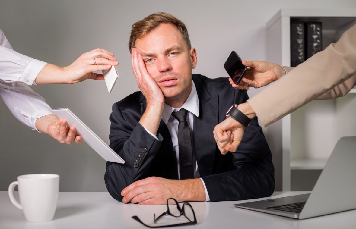 bărbat copleșit de prea multe sarcini la job