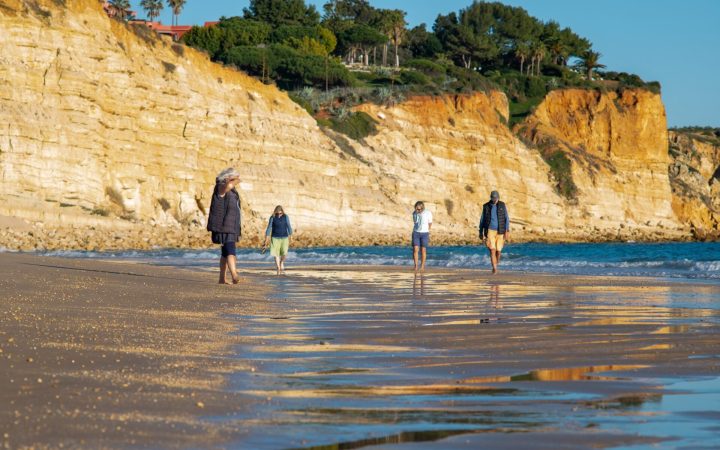 oameni care se plimbă pe plajă în Lagos, Portugalia, în februarie