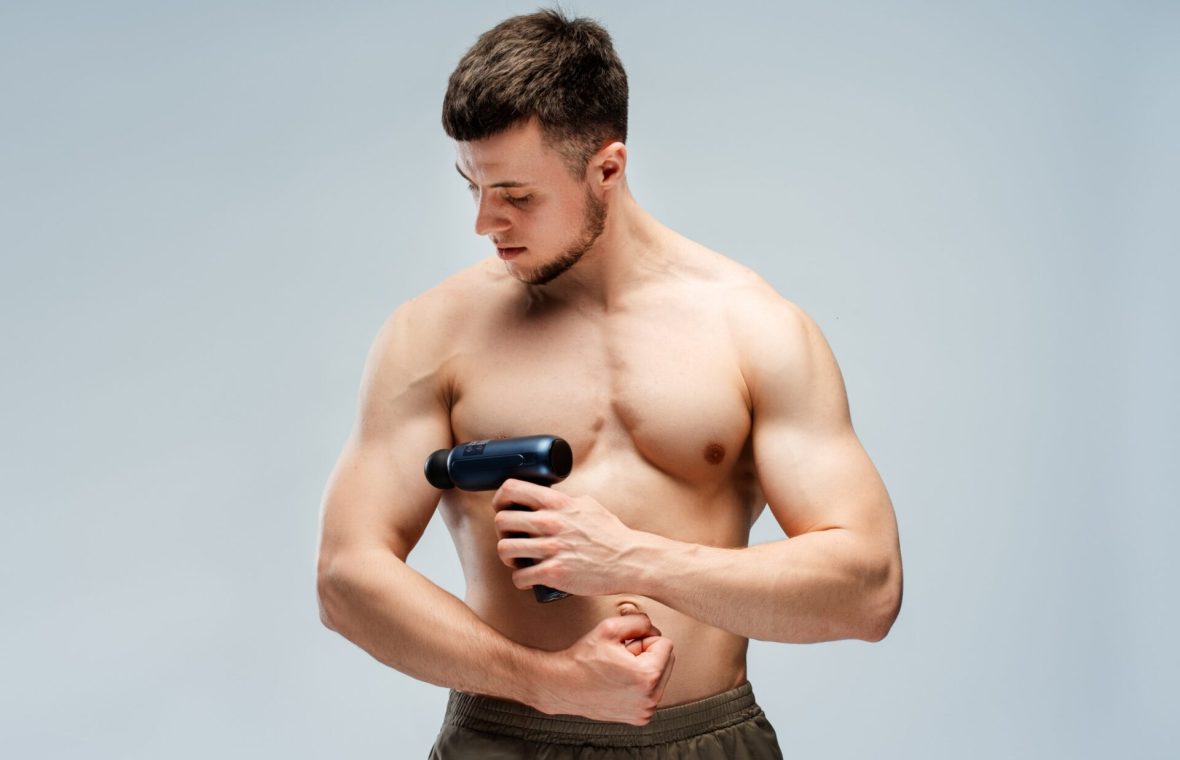 bărbat cu mușchi își face masaj la biceps pentru a combate febra musculară
