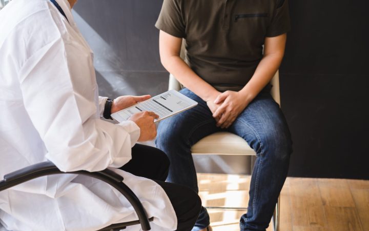 bărbat la medic, care se ține de zona pelviană pentru că are nevralgie pudendală