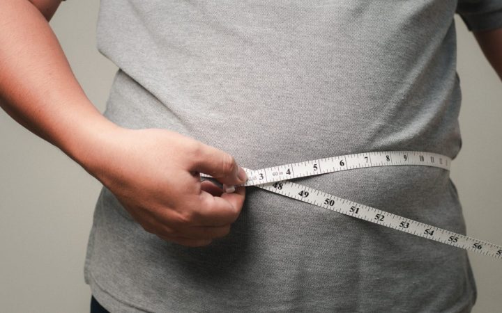 bărbat își măsoară talia mare cu un centimetru