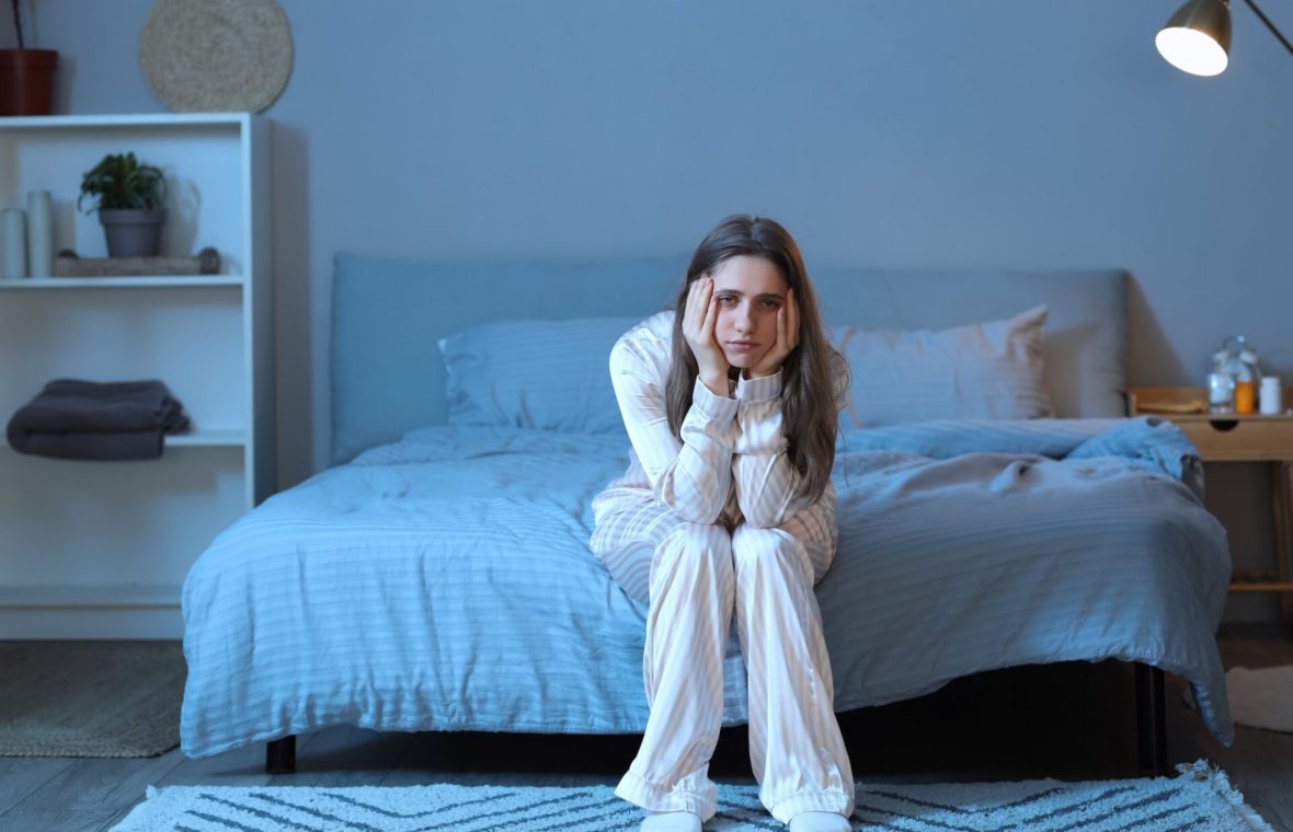 femeie pe marginea patului care nu poate să adoarmă noaptea - metode de a adormi mai repede