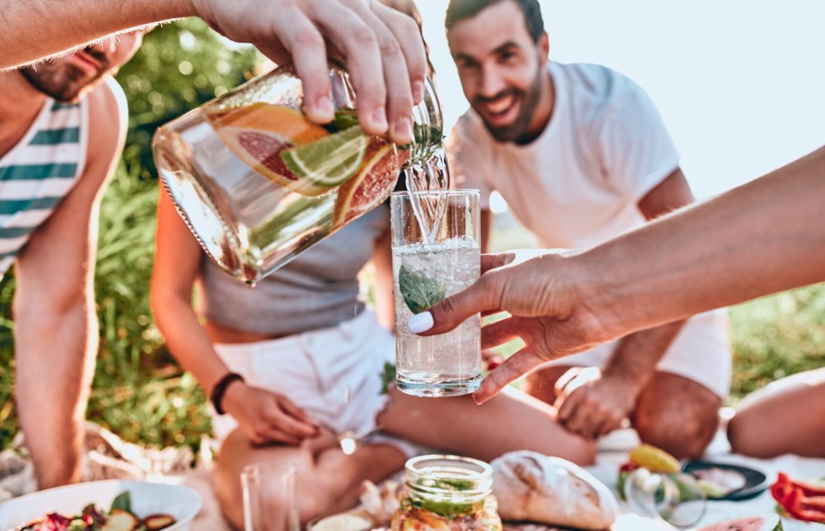 grup de prieteni care se distrează la iarbă verde bând limonadă - relaxare fără alcool