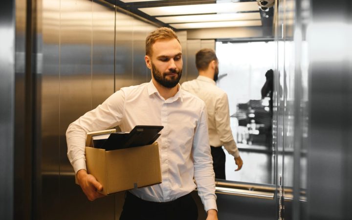bărbat concediat pleacă de la job cu lucrurile într-o cutie, dar nu e trist pentru că are flexibilitate mentală