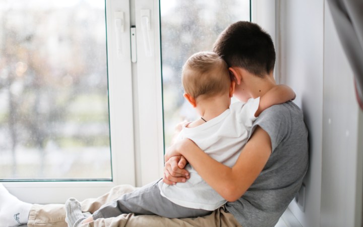 Copil parentificat - băiețel având grijă de fratele lui