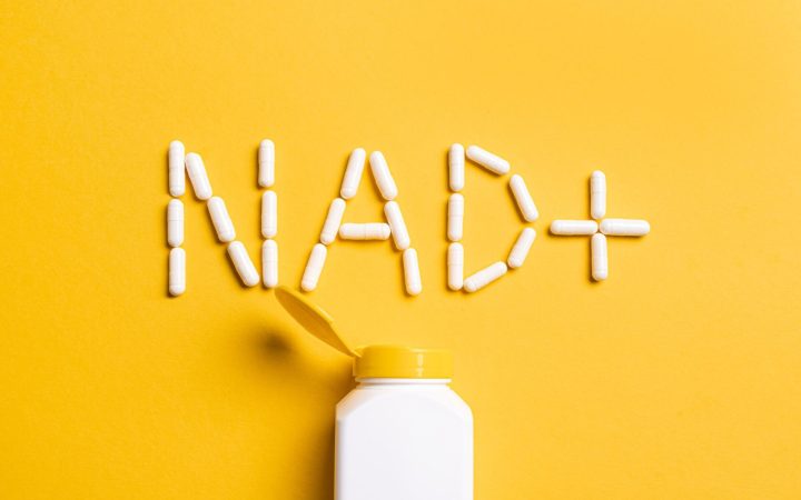suplimente NAD care desenează acronimul NAD+ pe fundal galben