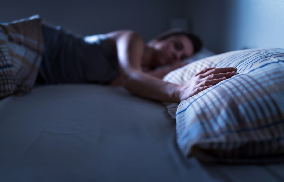 femeie tristă după o despărțire, care nu poate dormi și atinge perna partenerului