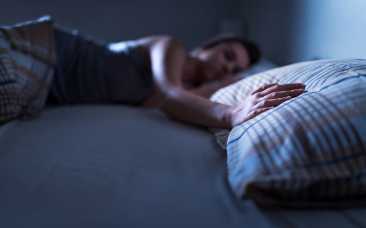 femeie tristă după o despărțire, care nu poate dormi și atinge perna partenerului