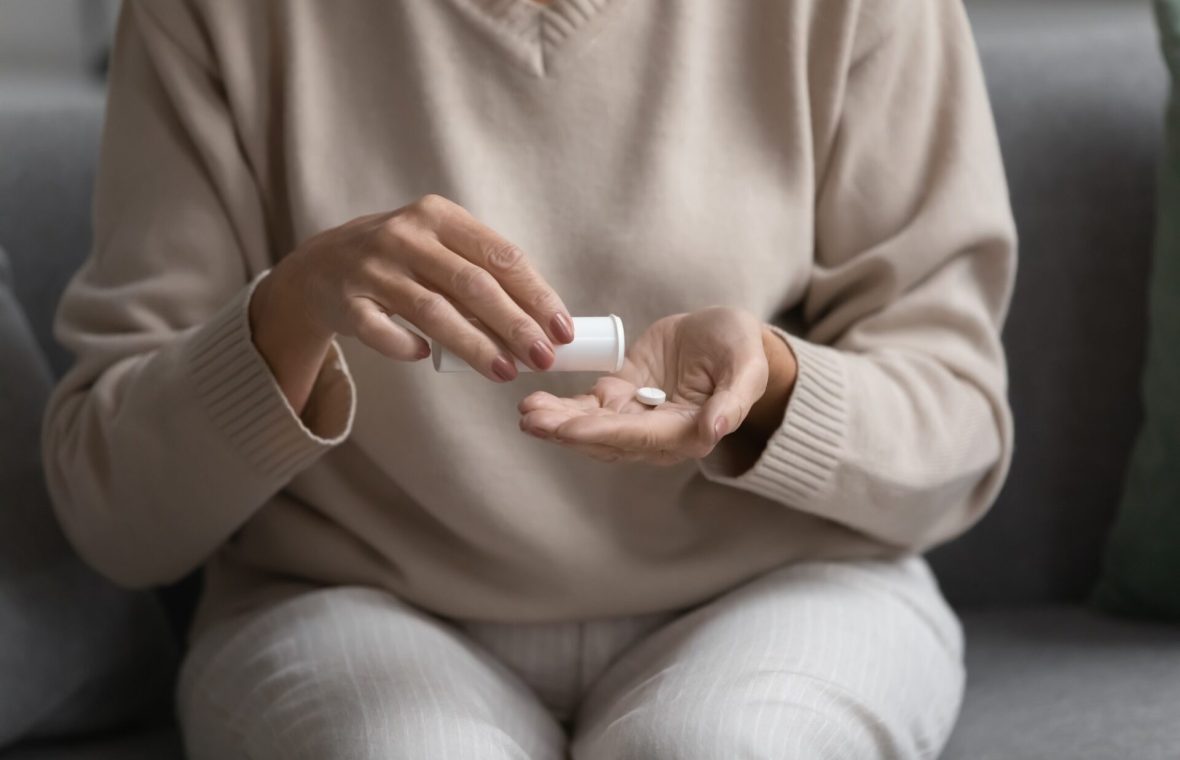 femeie care ia pastile pentru bufeurile de la menopauză