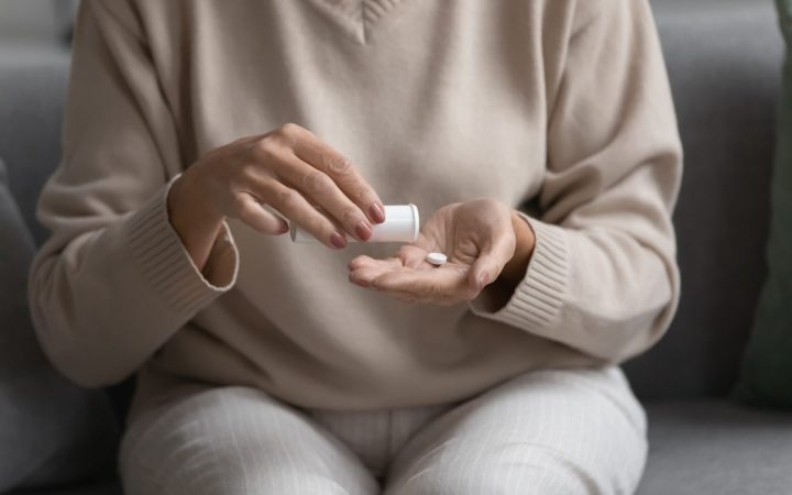 femeie care ia pastile pentru bufeurile de la menopauză