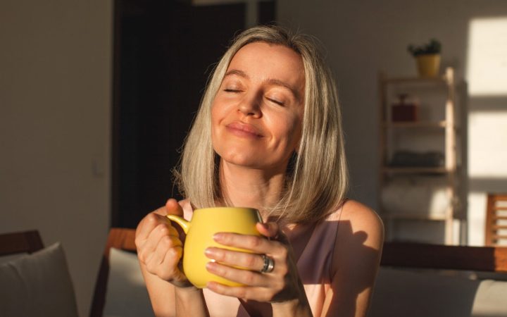 femeie fericită care bea cafea