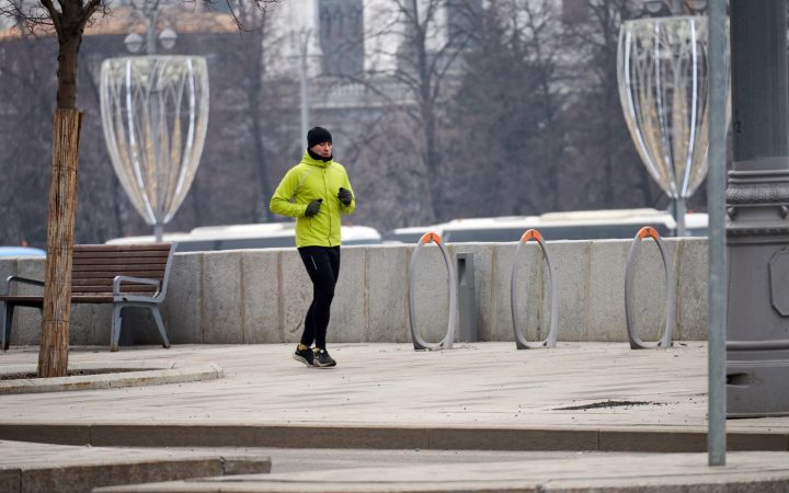 bărbat care face sport iarna în oraș și pare foarte obosit