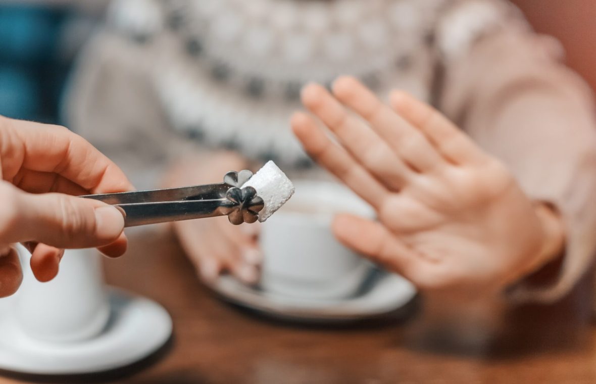 femeie refuză să adauge un cub de zahăr în cafea sau ceai