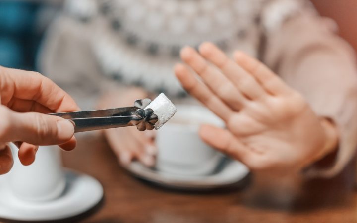 femeie refuză să adauge un cub de zahăr în cafea sau ceai
