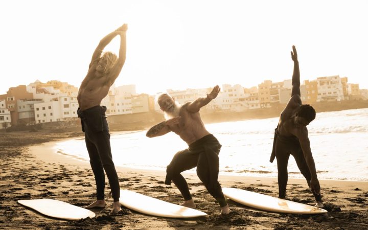 bărbați din generații diferite care se pregătesc pentru surf și care sunt în formă fizică bună