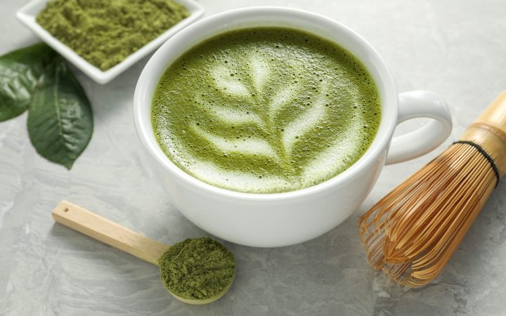 matcha cu lapte langa un castron cu pudra și un tel tradițional din bambus