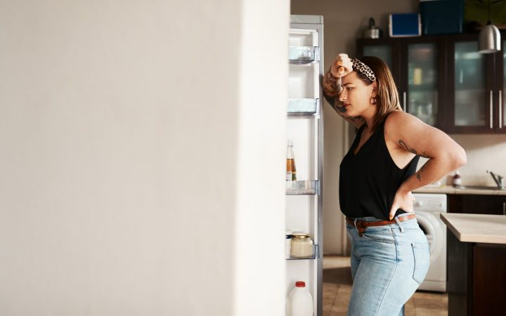 femeie plus size care caută mâncare în frigider