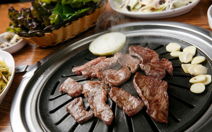 carne pe plită încinsă cu usturoi și ceapă