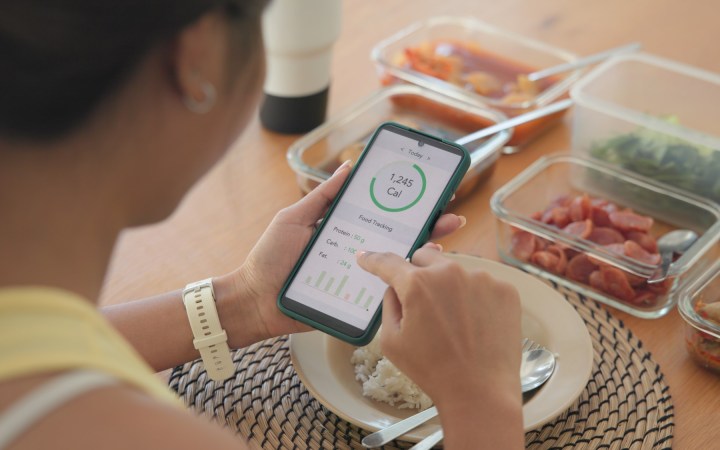 femeie care calculează caloriile cu ajutorul unei aplicații pe telefonul mobil