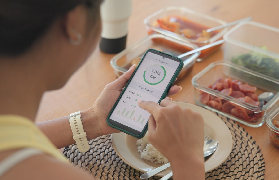 femeie care calculează caloriile cu ajutorul unei aplicații pe telefonul mobil